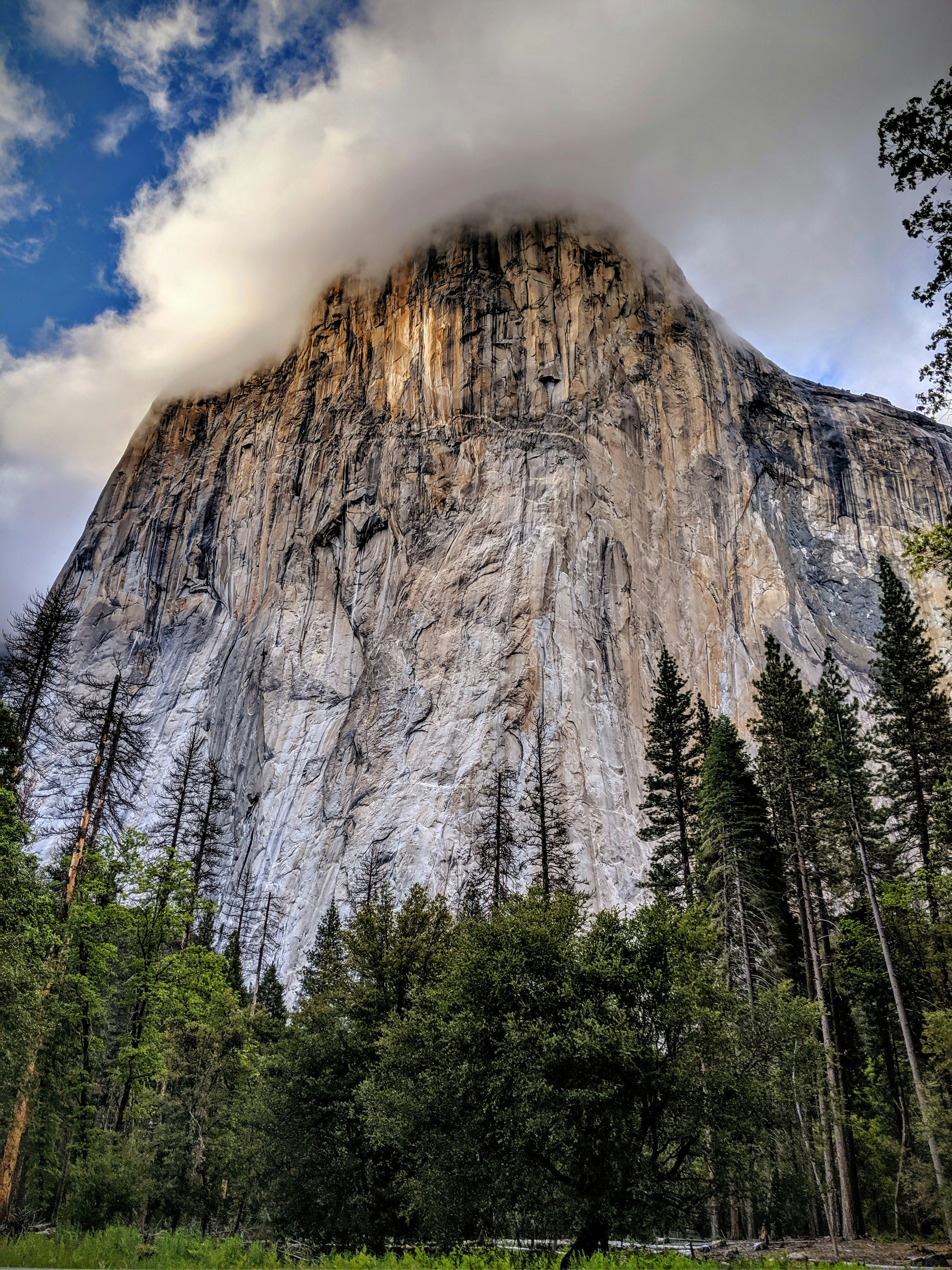 white clouds above rock mountain